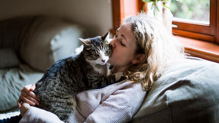 Femme embrassant un chat sur la joue