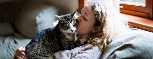 Femme embrassant un chat sur la joue